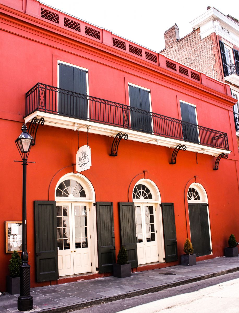 Bright red exterior of Le Petit Theatre in New Orleans.